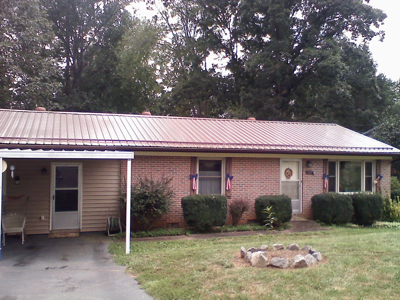 Bronze metal roof and carport on a brick ranch home — Roof Repair work by our crew in Brazil